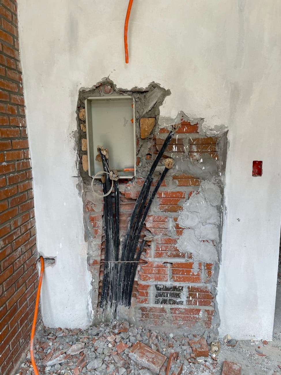 El tablero eléctrico embutido en el muro, con los caños negros bajando a la vista