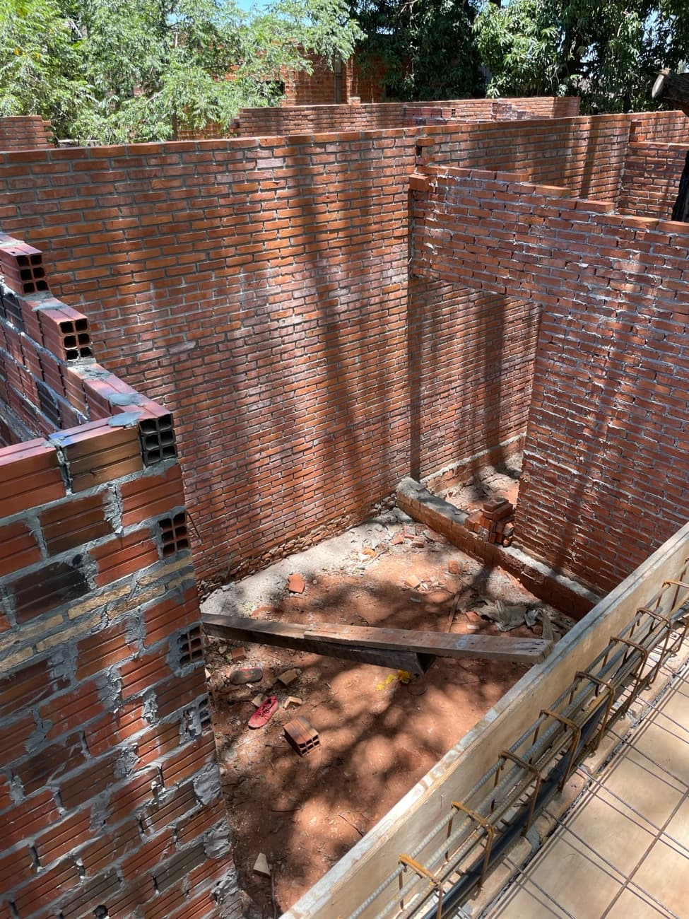 El patio visto desde arriba, con la sombra del árbol proyectada sobre el muro de ladrillo