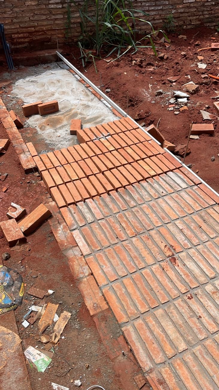 El piso de ladrillo en ejecución, con la mitad colocada y la mitad todavía en tierra